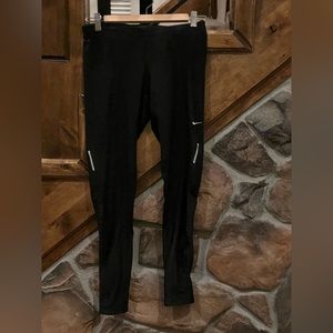 Nike running pant with zip back pocket and leg zippers at ankle. Ladies M